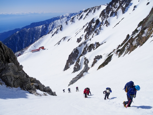 残雪の千畳敷カールを登山している人々